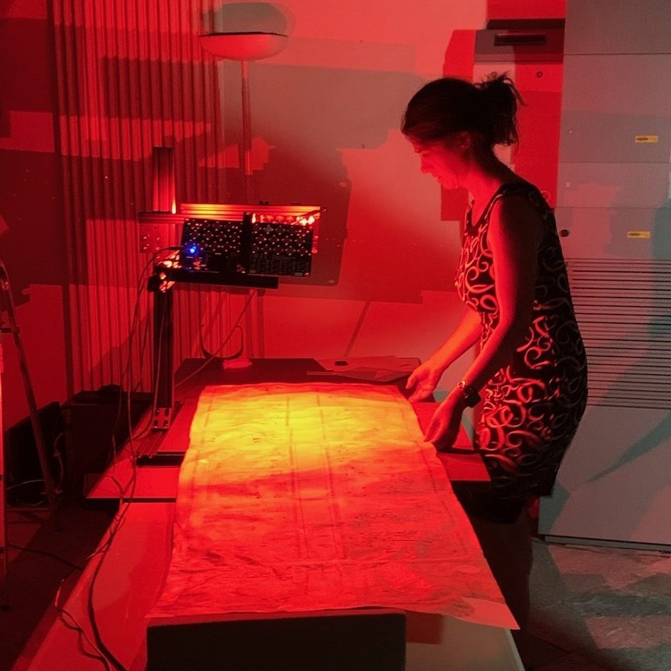 Picture of a woman holding a document under a red light